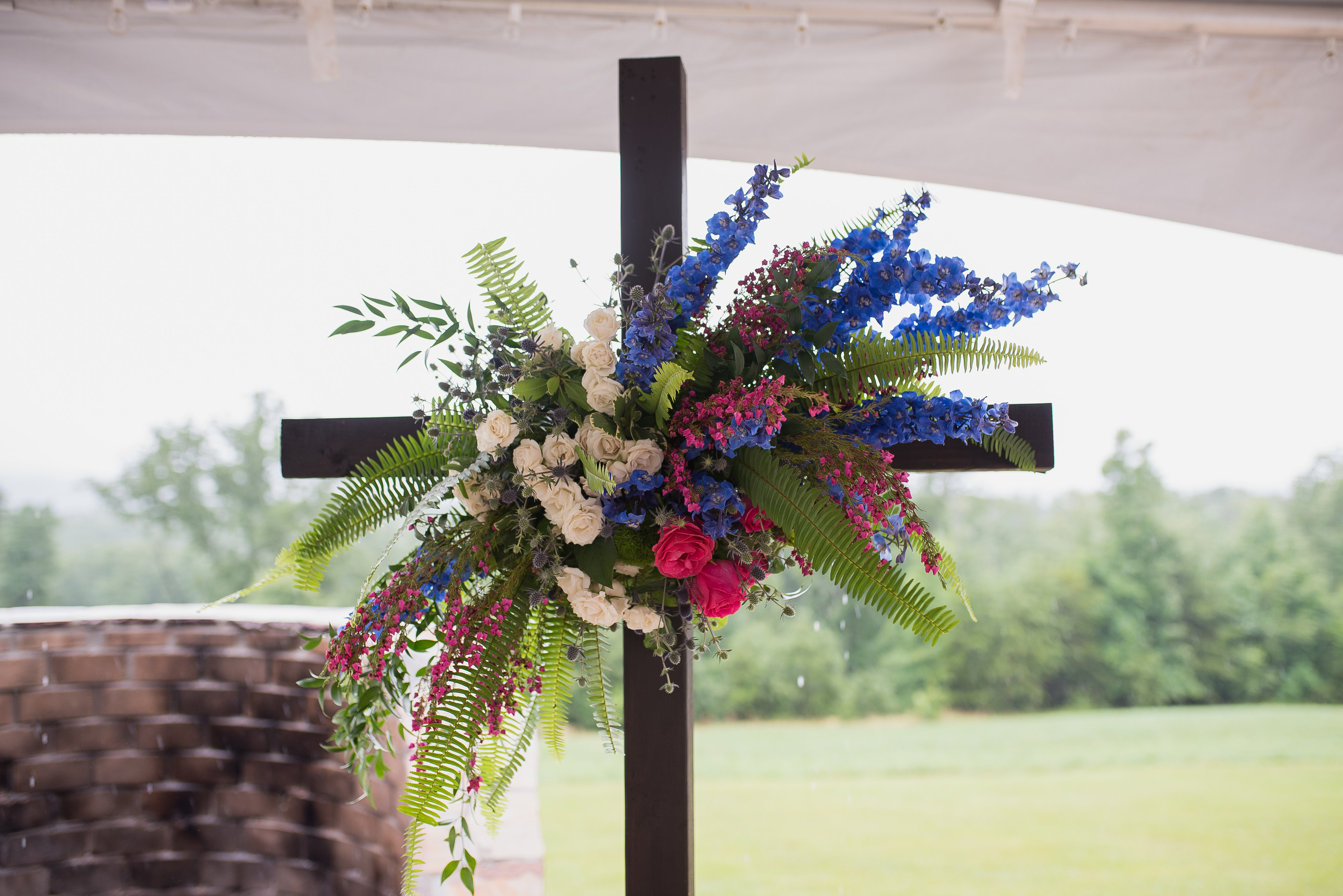 Cross with a colorful spring wedding flowers.