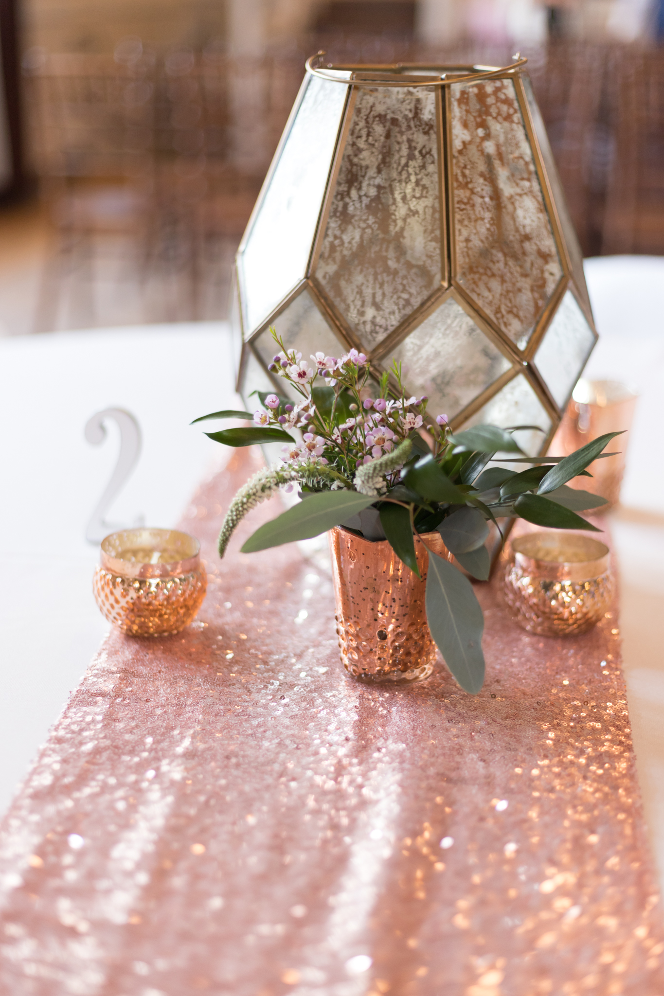 Geometric lanterns with votive candles and small vase with flowers embellished with sequin blush runner. bohemian flower types