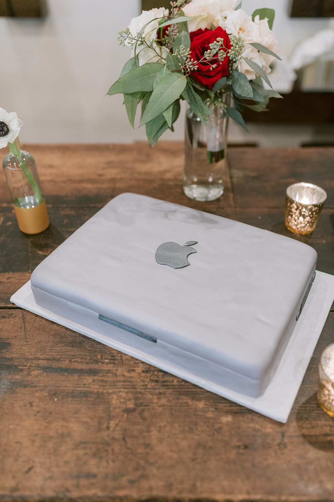 Apple Macbook wedding cake shown with wedding decor and toss bouquet at a Montaluce Winery Wedding