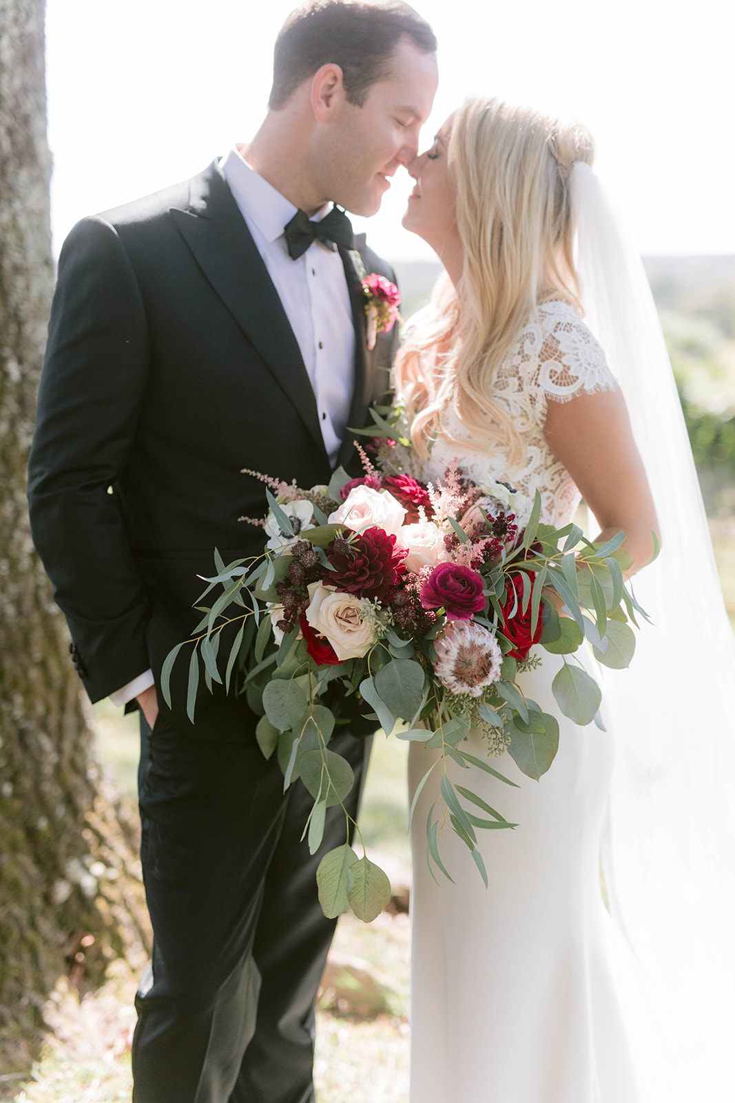 Bride and groom with a garden style bouquet in burgundy and blush