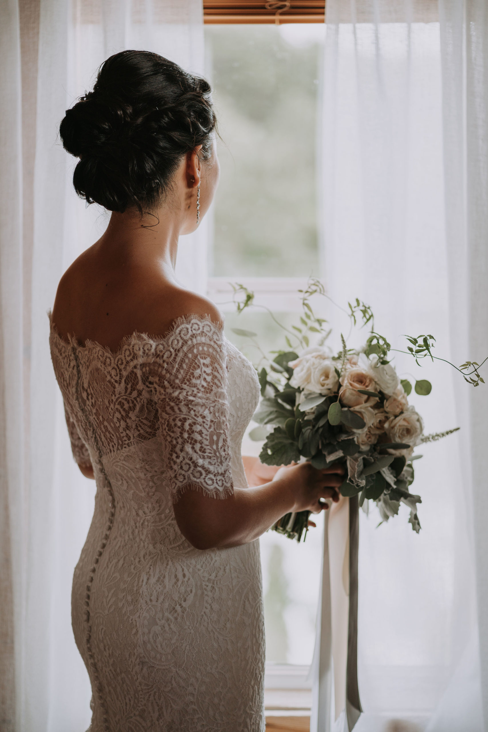 Bride looking away with her bridal bouquet. blush neutral color palette flowers 