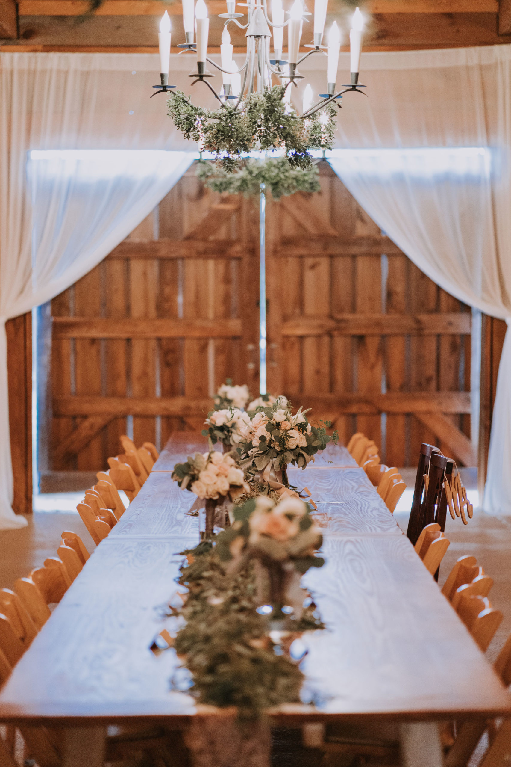 Barn estate table with blush flowers and garland along the 20 feet of table. 