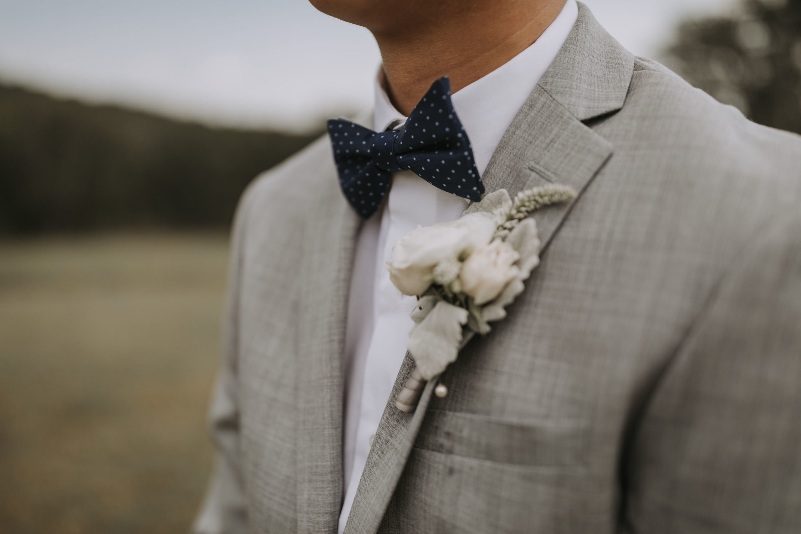Blush neutral palette flowers on a gray suit 